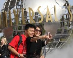 YouTube上传影片统计的全球热门10大求婚地点。图为中国游客在洛杉矶环球影城摄影留念。(ROBYN BECK/AFP/Getty Images)