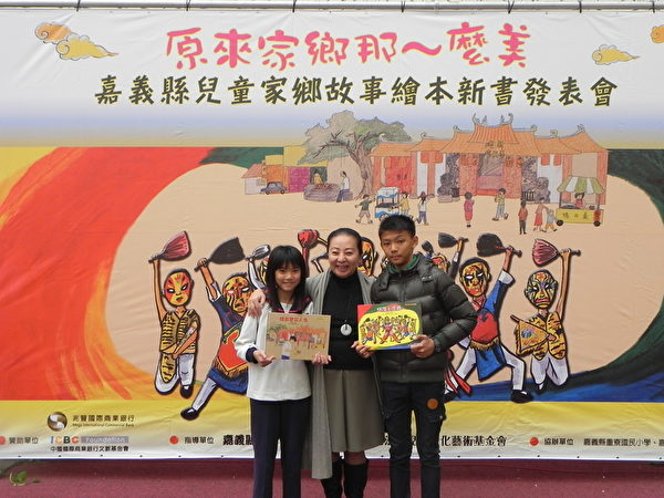 嘉义县重寮国小与月眉国小两所小学的学生代表将《城隍小家将》(右)与《烧出宝石人生》(左)两本故事绘本新书,呈现给县长张花冠(中)。(蔡上海/大纪元) 嘉义县重寮国小与月眉国小两所小学的学生代表将《城隍小家将》(右)与《烧出宝石人生》(左)两本故事绘本新书,呈现给县长张花冠(中)。(蔡上海/大纪元)