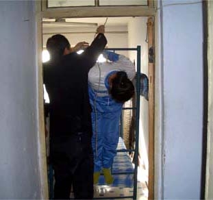 酷刑演示:吊铐(明慧网)