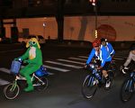 台北市长柯文哲（左2）27日从富贵角启程骑单车挑战“一日双塔”，历经15小时抵达台南，途中还遇到人型玩偶“Keroro”（左1）陪骑，相当有趣。
（台北市政府提供）