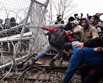 2016年2月29日，希臘與馬其頓邊界聚集了超過七千人，久候無望的難民，衝破封鎖線，試圖搗毀圍籬，越境到馬其頓。（LOUISA GOULIAMAKI/AFP/Getty Images）