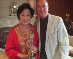 華裔製片人楊華沙與《雨人》編劇巴瑞‧莫若（Barry Morrow）和其獲獎小金人合影。（楊華沙提供）