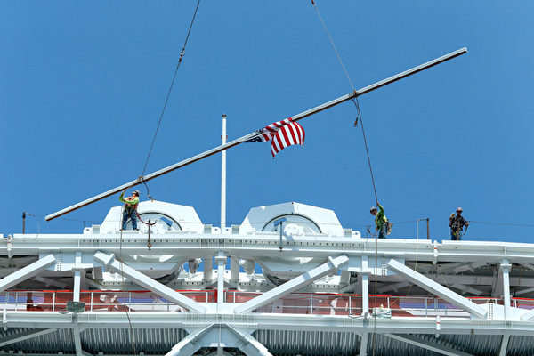 建筑工人正在放置亚瑟阿什球场顶棚支架的最后一根钢筋。（KENA BETANCUR/AFP/Getty Images） 