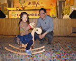 木作達人林昭賢(右)望著小朋友騎玩自己創作的木馬作品，感到很開心。（林怡欣／大紀元）