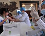 近日，山东公布庞某等非法经营疫苗案，问题疫苗波及全国24省市，涉案金额5.7亿元。图为北京民众正在接种疫苗。（AFP PHOTO）
