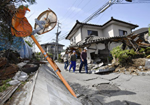 日本熊本县益城町14日遭规模6.5强震袭击,多处民宅损坏,马路龟裂隆起,路灯也倒塌。(共同社提供)