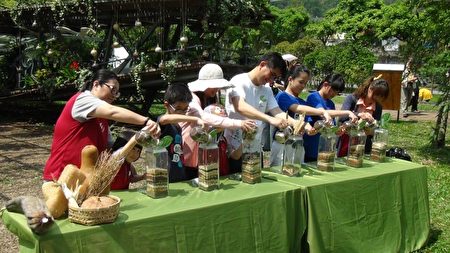 陈登钦局长邀请小朋友,将2016绿博开园迄今收到的种子,一起装填到玻璃罐里。(宜兰县政府提供)