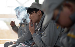 2016年2月，几名中国工人在湖北法国雷诺汽车生产线外面抽烟。（ JOHANNES EISELE/AFP/Getty Images)