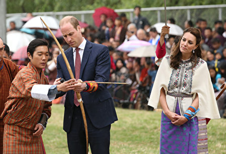 THIMPHU, BHUTAN - APRIL 14: Prince William, Duke of Cambridge fires an arrow as Catherine, Duchess of Cambridge looks on during an Bhutanese archery demonstration on the first day of a two day visit to Bhutan on the 14th April 2016 in Paro, Bhutan. The Royal couple are visiting Bhutan as part of a week long visit to India and Bhutan that has taken in cities such as Mumbai, Delhi, Kaziranga, Bhutan and Agra. (Photo by Chris Jackson/Getty Images)