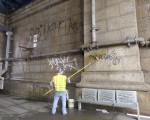 工作人員在清除華埠曼哈頓大橋下的塗鴉。（蔡溶/大紀元）