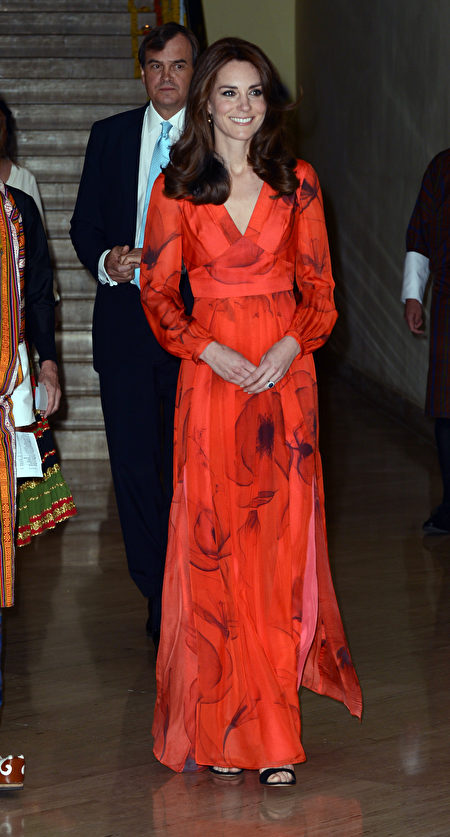 15日晚，威廉王子夫妇在不丹出席宴会时，凯特以一袭鲜红色长裙登场，裙上印有不丹国花罂粟花图案，亮丽打扮顿成全场焦点。(Mark Large - Pool/Getty Images)