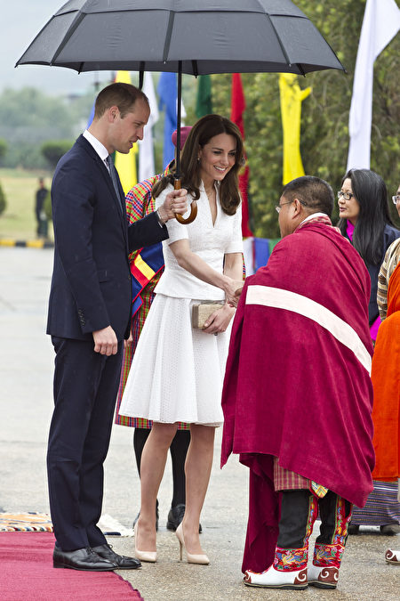 在离开不丹返回印度参观泰姬陵时，凯特换上一身白色衣裙，十分典雅。当日时值下雨，威廉打着一把大伞，为爱妻遮雨。 (Heathcliff O'Malley-Pool/Getty Images)