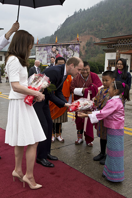 在离开不丹返回印度参观泰姬陵时，凯特换上一身白色衣裙，十分典雅。当日时值下雨，威廉打着一把大伞，为爱妻遮雨。 (Heathcliff O'Malley-Pool/Getty Images)