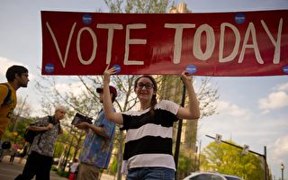 美国宾夕法尼亚州匹兹堡市一位居民，手持“请今天去投票”标识在街上行走。 ( Jeff Swensen/Getty Images)
