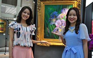 張宜真(左)和張宜如(右)是展覽場上最吸引人的一對美麗姊妹花，後方是張宜如的作品「思念」。（賴月貴／大紀元）