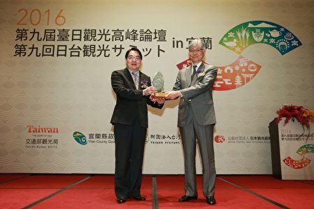交通部观光局局长谢谓君(左)、日本观光厅参与的本保芳明交换纪念品。(宜兰县政府提供)