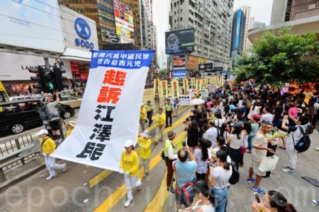 香港法輪功學員2015年7月19日舉行7.20聲援起訴江澤民大遊行，從北角到中聯辦，沿途吸引許多民眾觀看。（宋祥龍/大紀元）