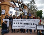 香港勞工團體「勞動力」成員聯合當地華裔團體於5月24日在伯班克市迪士尼公司總部前集會，為失業的深圳迪士尼玩具廠員工發聲。左一站立舉牌者為區立行。（組織者提供）