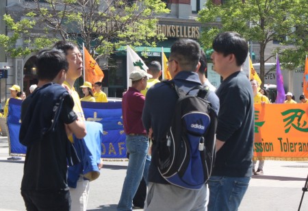 当天有不少华人来的现场观看功法演示与听法轮功学员讲真相。(骆亚/大纪元)