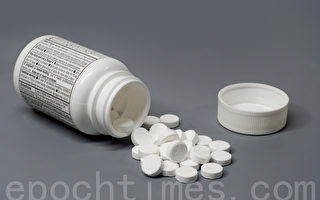 一瓶藥物或止痛藥灑在一個孤立的灰色背景（攝影:  / Tyler Panian - Fotolia）