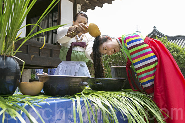 6月9日，韓國首爾南山韓屋村舉行端午節慶典千名中國遊客體驗韓國傳統文化與習俗。圖為用菖蒲水洗頭。（全景林／大紀元）
