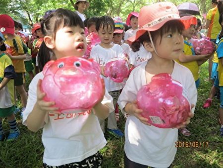 捧著粉紅豬公撲滿的小朋友模樣挺可愛。(新竹縣政府提供)
