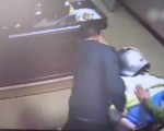 男子被警察戴上钢盔头罩及手铐，强行按在椅子上。（视频截图）