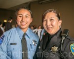 警察母親Cathy Fong（右）為自己女兒戴上結業章。（李文淨／大紀元）