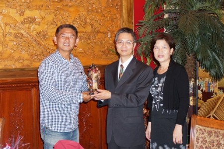 图:休士顿台联会会长陈焕泽(左)向即将荣退的台北办事处经济组陈福生组长伉俪赠送艺术品留念。(易永琦/大纪元)