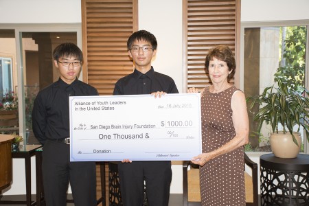 AYLUS聖地亞哥分會會長Christopher Yang(中)和Stephen Yang代表會員將籌集的1000美元捐款轉交聖地亞哥腦損傷基金會執行長Susan Hansen。(楊婕/大紀元)