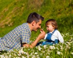 Father and son picking flowers and having fun on meadow