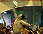 2003年8月青岛啤酒节上,一名男子炫耀喝光了一杯啤酒。（Getty Image）