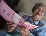2006年9月，上海一名老婦人收到養老金。(China Photos/Getty Images)