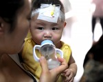 2008年9月，三聚氰胺毒奶粉事件后，成都儿童医院，一名妇女在喂食一名患病婴儿。(China Photos/Getty Images)