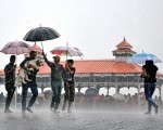 中共的御用「智庫」對印度的崛起進行了錯誤的解讀，誤導了中國人民。圖為今年6月印度梅雨期間行人帶著狗路過一個庇護所。（Getty Images）