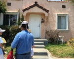 图:洛杉矶范先生和女儿在新买就被陌生人占住的房子前。( 刘菲/ 大纪元 )