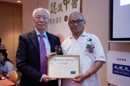 聯辦單位馬來西亞中醫師暨針灸聯合總會代表頒發感謝狀於主講人之一胡乃文醫師。(黃樹聰/大紀元)