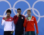 圖為「飛魚」菲爾普斯（Michael Phelps）（中）和銀牌得主日本選手阪井聖人（Masato Sakai）（左）及銅牌得主匈牙利泳將塔馬斯．肯德瑞西（Tamas Kenderesi）在領獎台上。(Odd ANDERSEN/AFP)