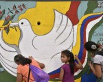 哥伦比亚政府与反叛武装宣布停火，该国历时52年的内战走向终结。图为哥伦比亚民众在一处墙上画上象征和平的图画。（AFP PHOTO / GUILLERMO LEGARIA）