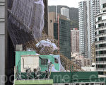 台风“妮妲”吹袭香港期间，湾仔菲林明道7号一幢商业大厦外墙约10层楼高的棚架倒塌，运输署一度将轩尼诗道往中环方向近菲林明道的全线封闭。（余钢／大纪元）