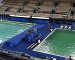 奥运跳水池和水球池相继转绿，奥运官员表示，保证池水将转回蓝色。图为8月10日，水球池（左）和跳水池（右）。(CHRISTOPHE SIMON/AFP)
