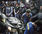 馬尼拉8月12日發生涉嫌越獄及企圖綁架典獄長未遂事件，造成10名犯人死亡。圖為，武裝警衛站在囚犯的屍體旁。(JAKE C SALVADOR/AFP)