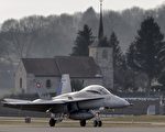 A F/A-18 Hornet fighter aircraft of the Swiss Air Force is seen in front of a church on February 20, 2013 at Payerne airport.  AFP PHOTO / FABRICE COFFRINI        (Photo credit should read FABRICE COFFRINI/AFP/Getty Images)