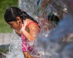 7月25日位于华盛顿特区的一个公园内，一个女孩在喷泉下冲凉，抵御高温。( JIM WATSON/AFP/Getty Images)