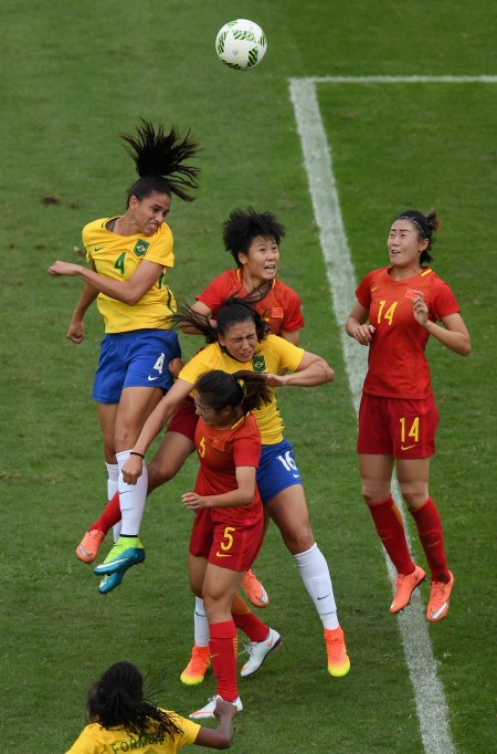 RIO DE JANEIRO, BRAZIL - AUGUST 03: Rafaelle of Brazil (4) outjumps the China defence during the Women's Group E first round match between Brazil and China PR during the Rio 2016 Olympic Games at the Olympic Stadium on August 3, 2016 in Rio de Janeiro, Brazil. (Photo by Shaun Botterill/Getty Images)