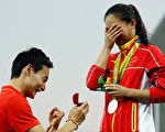 拿到铜牌的秦凯在跳水馆向刚刚获得银牌的何姿当众求婚，俩人表情令人喜悦。（Clive Rose／Getty Images）