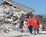 意大利中部24日发生里氏6.2强震，导致多座古城小镇严重受损。图为重灾区阿马特里切镇，在现场搜救的救难人员。
(ANDREAS SOLARO/AFP/Getty Images)