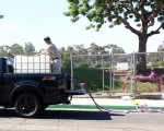 图：2016年7月30日，圣地亚哥市供水区首次为居民客户提供免费循环水（Recycled Water），用以清洗庭院、浇灌植物、洗车等，但不能做为饮用水。图为一名居民将从紫色水管流出的循环水装入卡车上的巨大容器。（圣地亚哥市公共事业部提供）