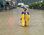 高市鼓山區厚生里9月連續颱風衝擊下，一個月淹水3次，里長歐瑞清水中指揮交通，相當無奈。（高雄市國民黨部提供）