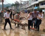 浙江省一名教育局官員在視察災區時因一張「攙扶照」引起網絡熱議。（網絡圖片）